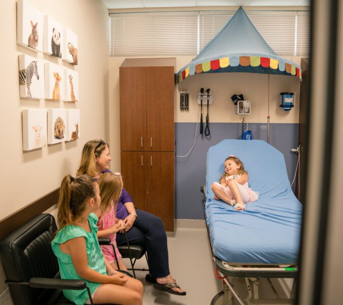 Parent, siblings and child patient in pediatric patient room at iCare Emergency Room & Urgent Care in Frisco, TX.